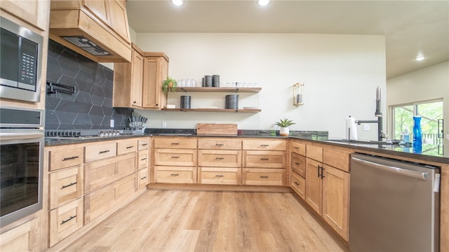 kitchen featuring light brown cabinetry, stainless steel appliances, sink, light hardwood / wood-style floors, and backsplash