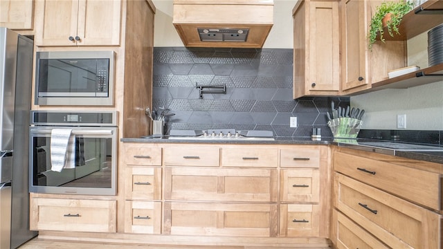 kitchen with wood-type flooring, light brown cabinetry, custom range hood, appliances with stainless steel finishes, and backsplash