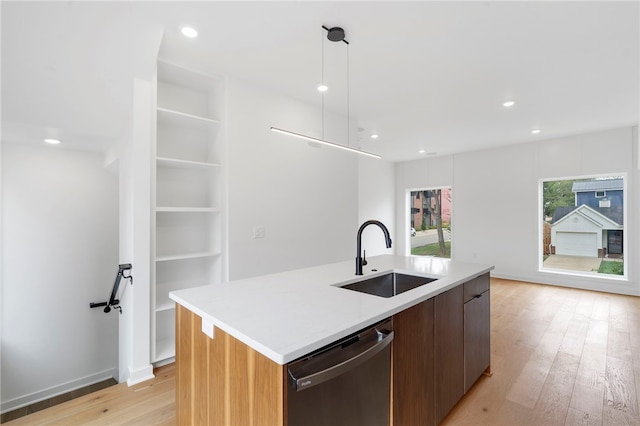 kitchen with stainless steel dishwasher, modern cabinets, light wood finished floors, and a sink