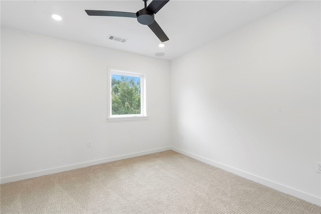 empty room featuring light carpet, visible vents, and baseboards