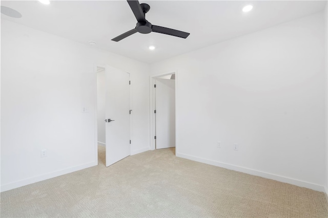 spare room with a ceiling fan, recessed lighting, light colored carpet, and baseboards