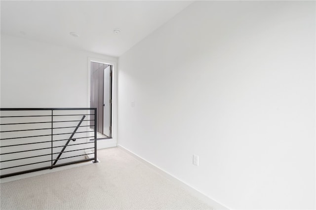 unfurnished room with light carpet and baseboards