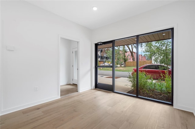 spare room with recessed lighting, baseboards, and wood finished floors