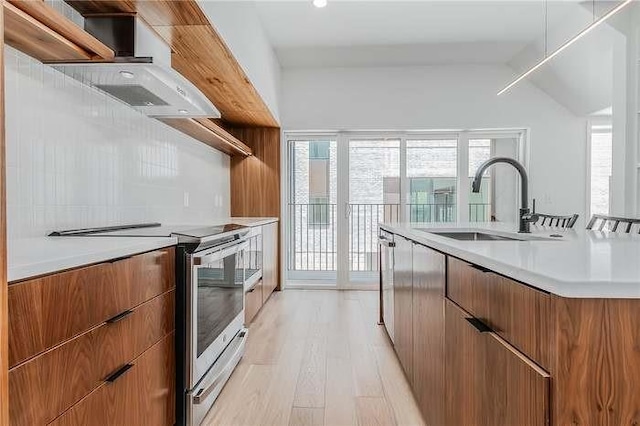 406 SE G St, Bentonville, AR 72712 - kitchen with light countertops, appliances with stainless steel finishes, light wood-style floors, brown cabinetry, and a sink