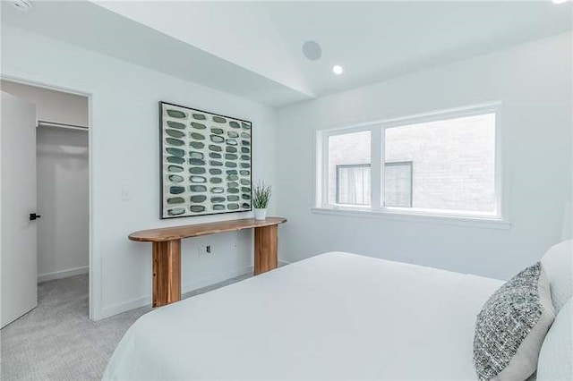 bedroom featuring lofted ceiling, recessed lighting, light carpet, baseboards, and a spacious closet