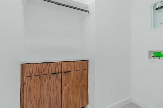 clothes washing area featuring washer hookup and baseboards