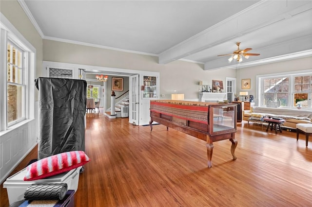 playroom with wood-type flooring, ornamental molding, ceiling fan, and beam ceiling