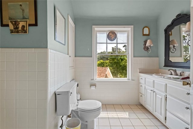 bathroom with vanity, tile walls, tile patterned floors, and toilet