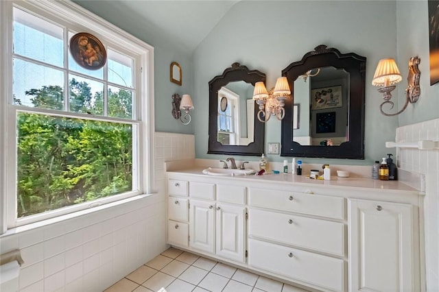 bathroom featuring tile patterned floors, vaulted ceiling, vanity, and tile walls