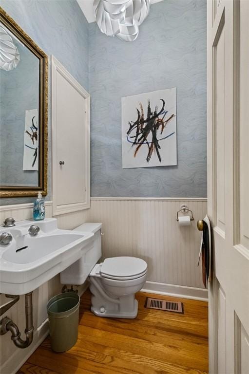 bathroom featuring wood-type flooring and toilet