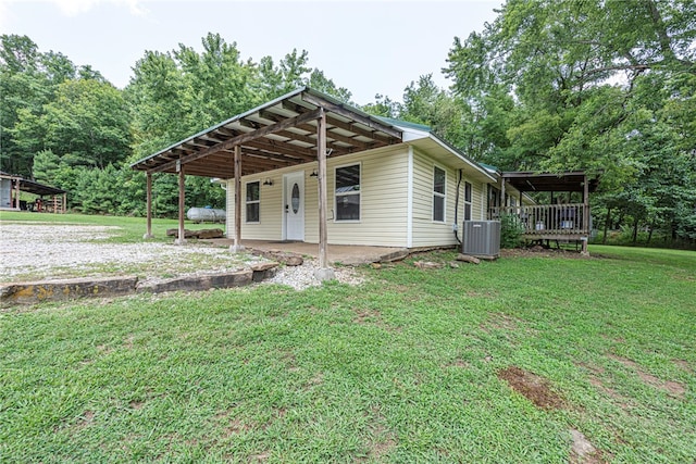 back of house with central AC and a lawn