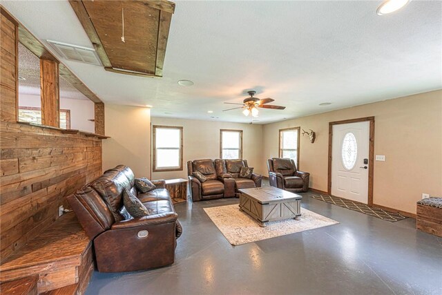 living room with a textured ceiling and ceiling fan