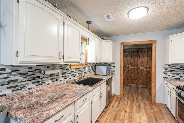 kitchen with light hardwood / wood-style floors, sink, white cabinetry, and stainless steel appliances