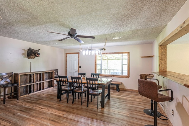 dining area featuring a textured ceiling, hardwood / wood-style flooring, and ceiling fan