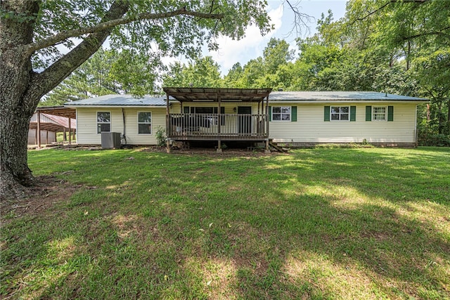 rear view of house with cooling unit, a wooden deck, and a yard