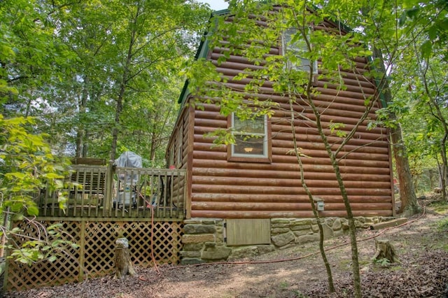 view of home's exterior with a deck and log veneer siding