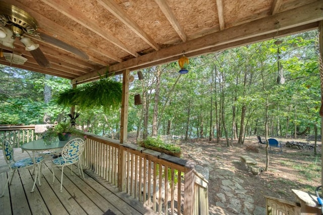 deck featuring a wooded view and outdoor dining area