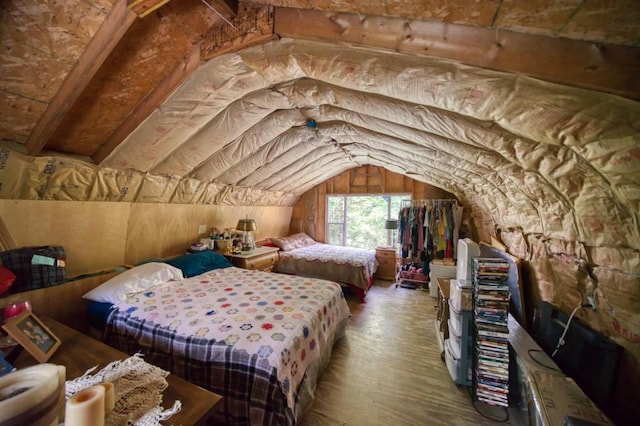 bedroom with vaulted ceiling and wood finished floors