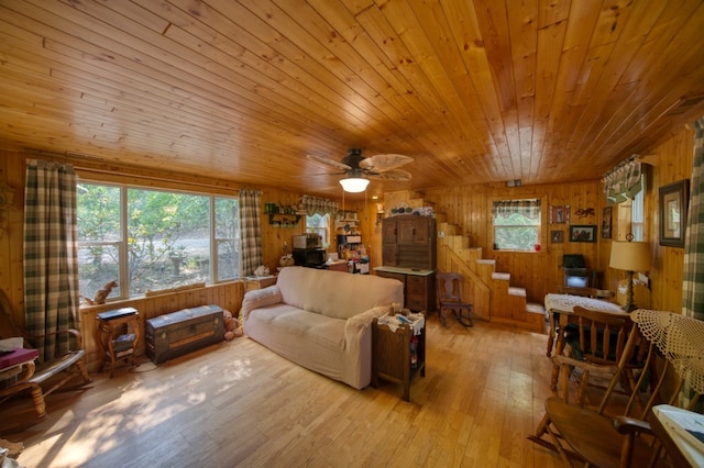 living room with wood walls, wooden ceiling, ceiling fan, and light hardwood / wood-style floors