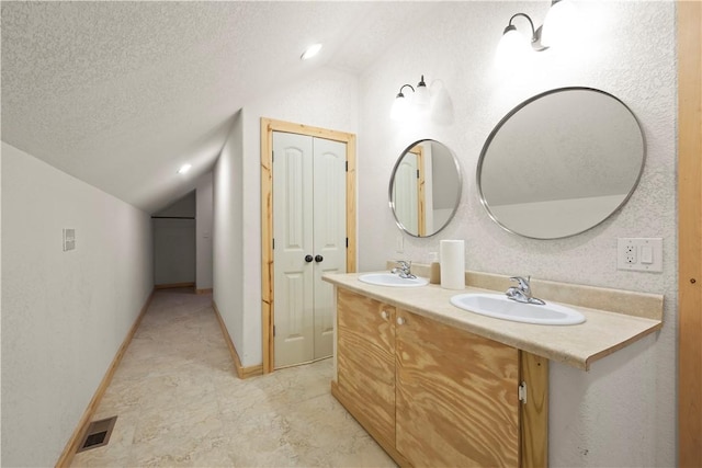 full bathroom with vaulted ceiling, visible vents, double vanity, a sink, and a textured ceiling