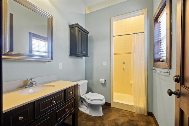 full bathroom featuring a tile shower, toilet, and vanity