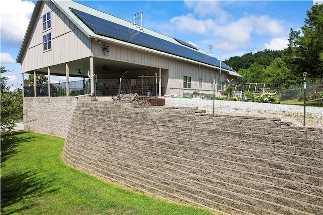 rear view of property featuring solar panels