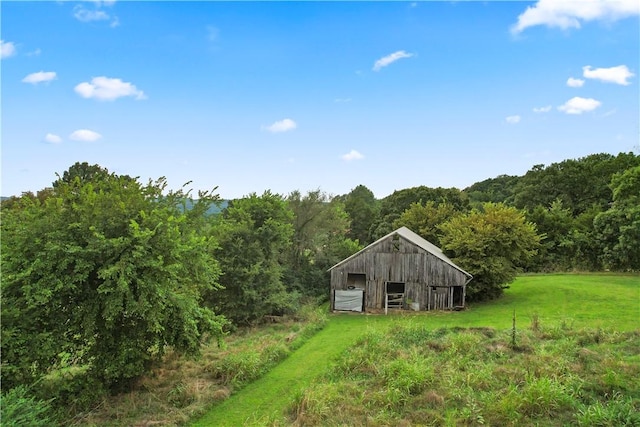 view of pole building featuring a yard and a wooded view