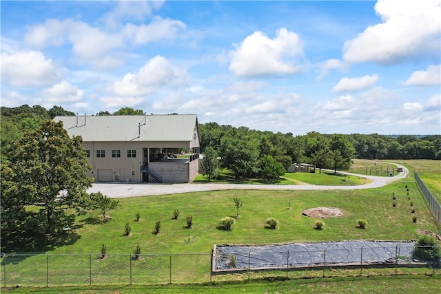 exterior space featuring a lawn, stairway, fence, and driveway
