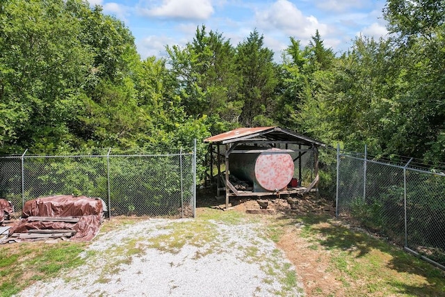 view of yard with fence and dirt driveway