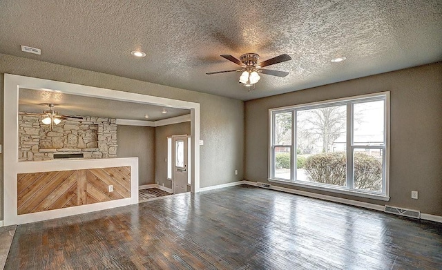 unfurnished living room with ceiling fan, hardwood / wood-style floors, and a textured ceiling