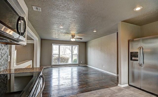 kitchen featuring stainless steel appliances, ceiling fan, a textured ceiling, and light hardwood / wood-style floors