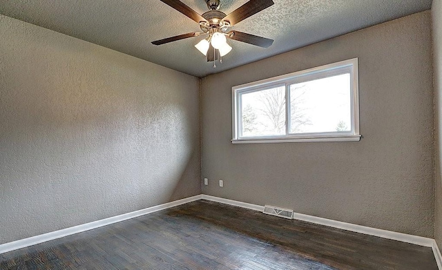 unfurnished room with dark hardwood / wood-style floors, a textured ceiling, and ceiling fan