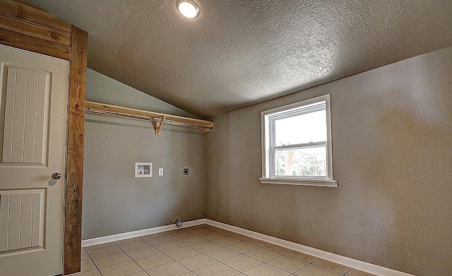 laundry area featuring washer hookup, hookup for an electric dryer, a textured ceiling, and light tile patterned floors