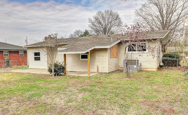 rear view of property featuring a patio and a yard