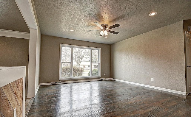 empty room featuring a textured ceiling, dark wood-type flooring, and ceiling fan