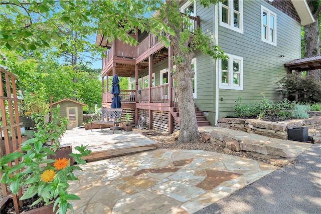 exterior space featuring a wooden deck and a storage unit