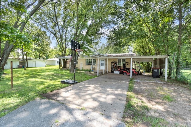 view of front of house featuring a carport, a front yard, and a storage shed