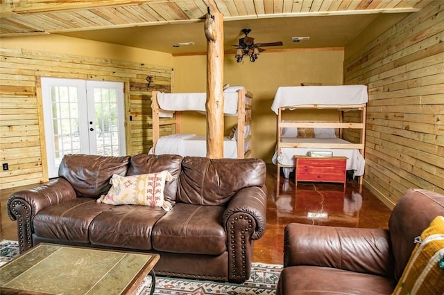 living room featuring wood ceiling, french doors, ceiling fan, and wood walls