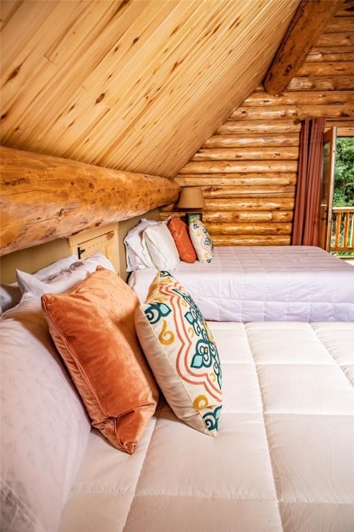 unfurnished bedroom featuring access to exterior, lofted ceiling with beams, wooden ceiling, and rustic walls