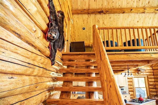 stairs featuring beamed ceiling and rustic walls