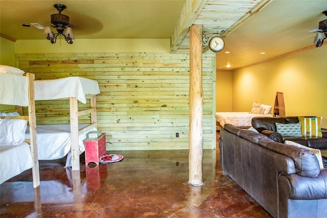 bedroom with ceiling fan and wood walls