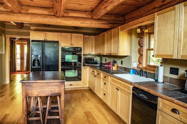 kitchen featuring sink, light brown cabinetry, light hardwood / wood-style floors, and black appliances