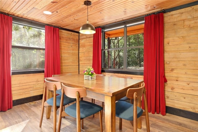 dining area featuring wooden walls, wooden ceiling, and light wood-type flooring