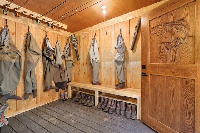 mudroom featuring dark wood-type flooring, wooden ceiling, and wooden walls