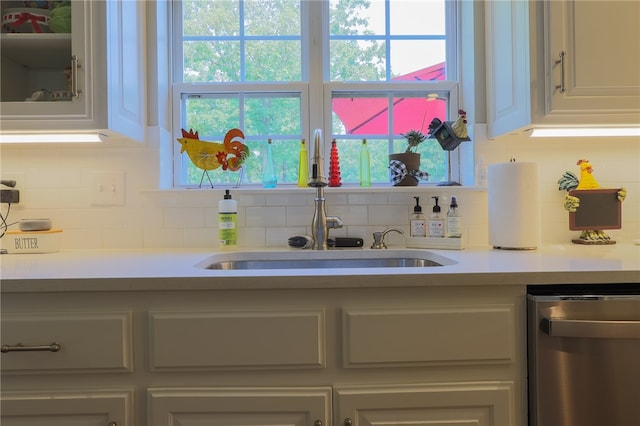 kitchen with a wealth of natural light, sink, dishwasher, and tasteful backsplash