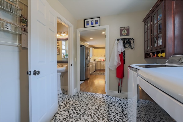 laundry room with light wood-type flooring, cabinets, and independent washer and dryer