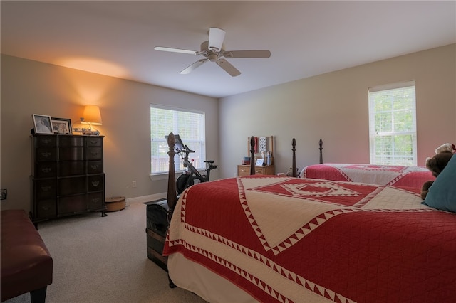 bedroom with light carpet, multiple windows, and ceiling fan