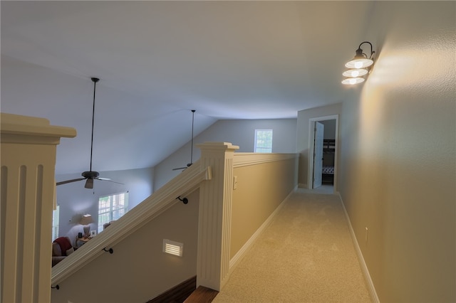 corridor with carpet flooring and vaulted ceiling