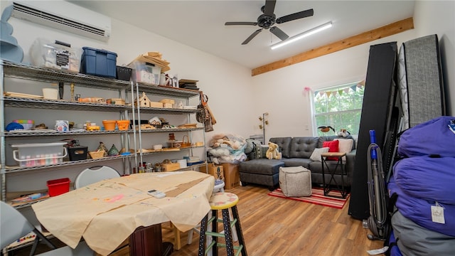 interior space featuring ceiling fan, light hardwood / wood-style flooring, and a wall mounted air conditioner