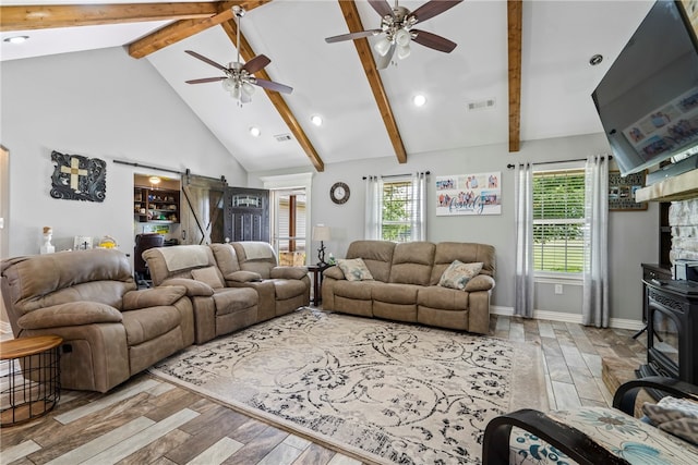 living room with beamed ceiling, light hardwood / wood-style flooring, a barn door, and ceiling fan